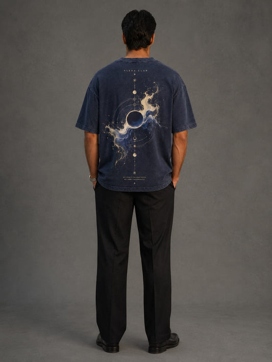 Back view of FlexaClub's acid washed drop shoulder T-shirt featuring a cosmic solar eclipse graphic paired with black trousers.