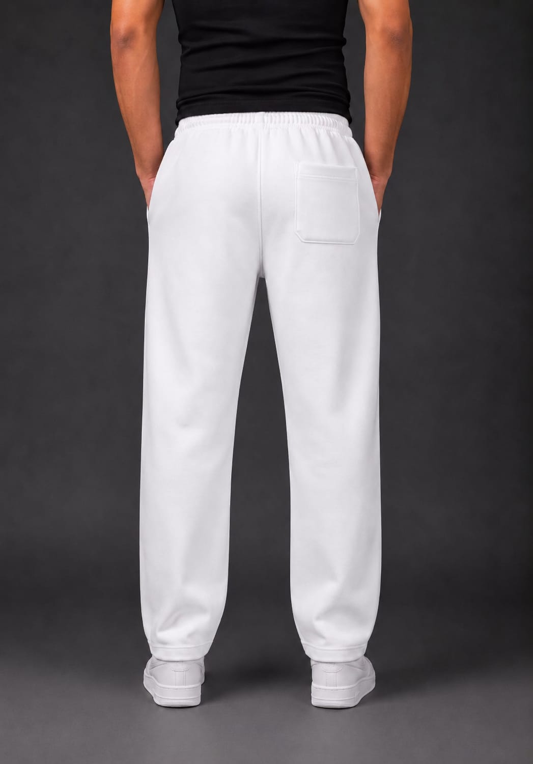 White sweatpants with a back pocket, modeled from the back on a person wearing a black shirt and white sneakers against a dark gray studio background.