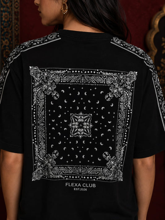 A person shown from the back wearing a black drop shoulder T-shirt with a large white bandana-style graphic print across the back and the text 'FLEXA CLUB EST.2016' near the lower back.