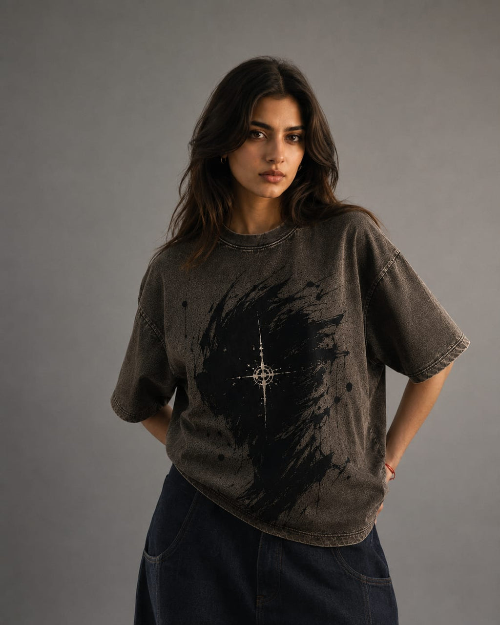 Woman wearing a dark t-shirt with a star design on a gray background